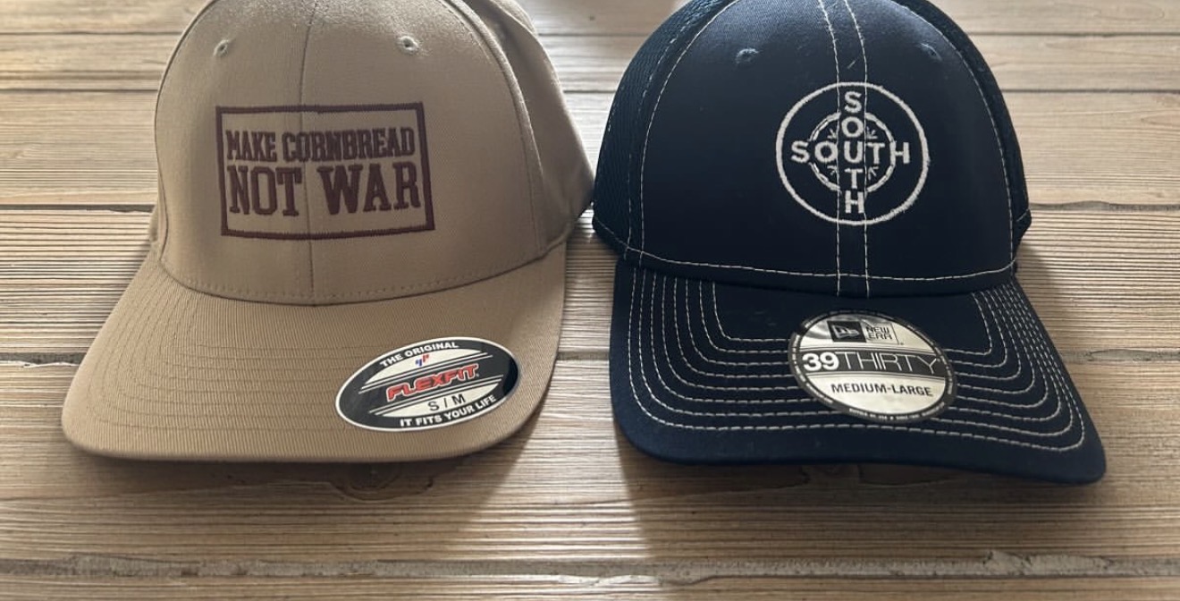 Two embroidered caps, a tan flexfit and a navy trucker, with custom logos